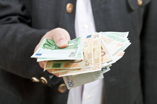 fanned euro banknotes in bisnessman hands