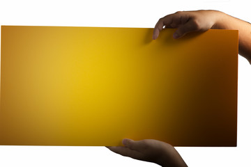 Plywood yellow sign held up by hands