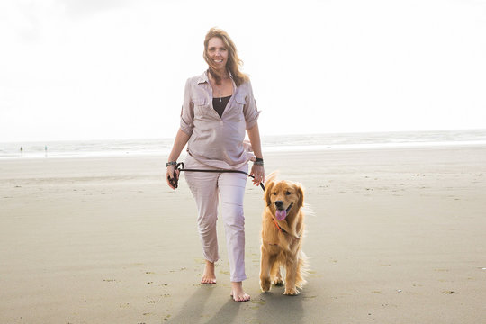 woman walking her dog at the beach