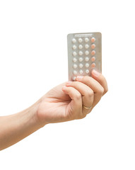 Woman hand holding contraceptives over white background