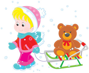 Child walking with a sled and toy bear
