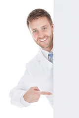 Happy Male Doctor Displaying Billboard
