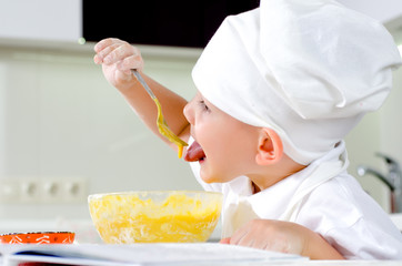 Cute little chef tasting his cooking