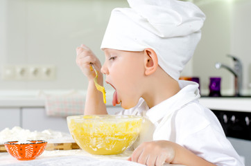 Cute little chef tasting his cooking