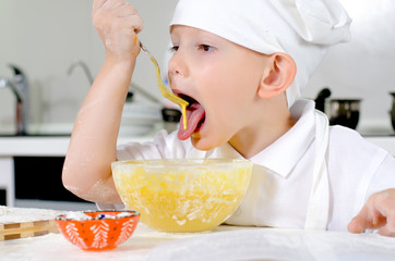 Cute little chef tasting his cooking