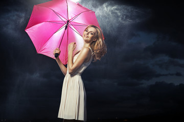 Cheerful blonde lady with the pink umbrella