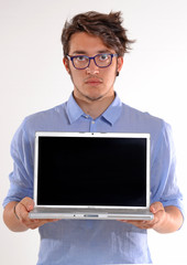 Hombre joven mostrando la pantalla de un ordenador portátil.