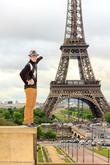 Young man hipster shows the Eiffel tower, France