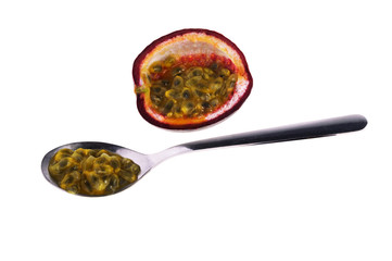 Passion fruit seeds on a spoon isolated on white background
