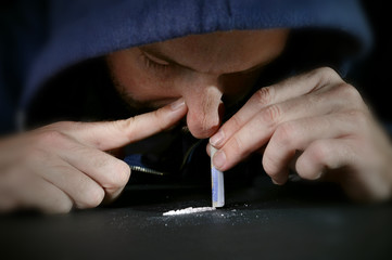 drug addict man snorting cocaine line with rolled banknote
