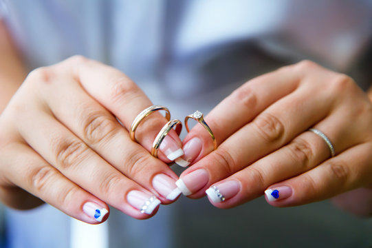 Bride putting on an engagement ring and wedding ring