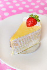 Crape cake with strawberry topping on pink dot