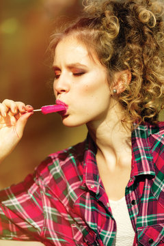 Young Beautiful Girl In A Plaid Shirt Eating Popsicles