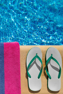 Pair of flip flop thongs and a towel at the swimming pool