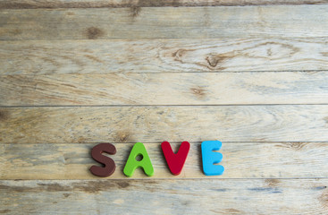 Colorful wooden word Save on wooden floor3