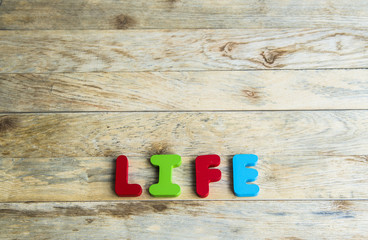Colorful wooden word Life on wooden floor3
