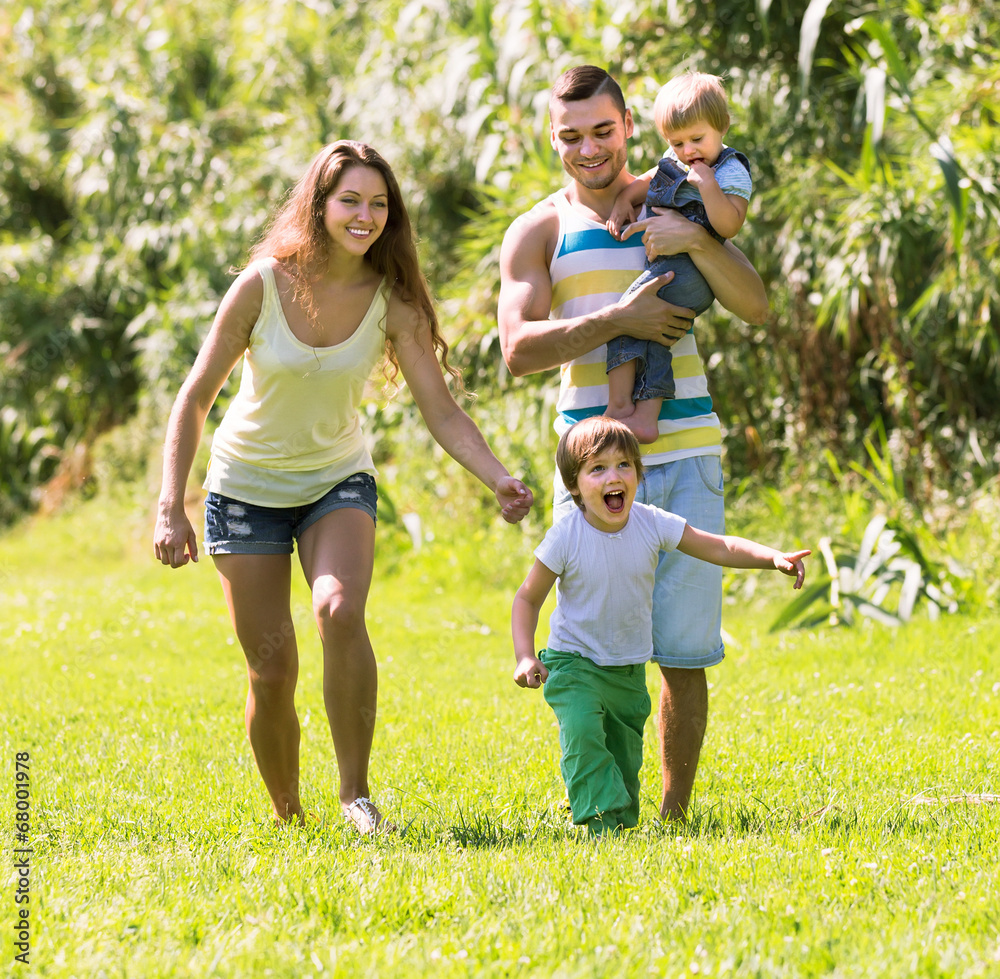 Wall mural family of four in sunny park