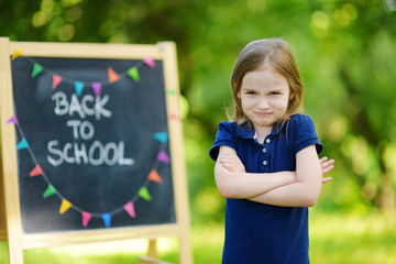 Adorable girl being unhappy about going to school