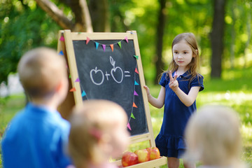 Adorable little girl playing a teacher
