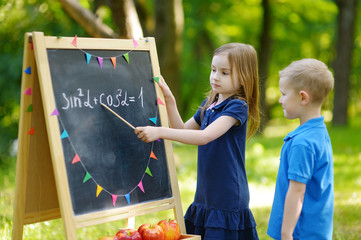 Adorable little girl playing a teacher