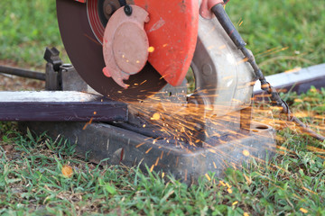 Worker cutting metal with cutting machine
