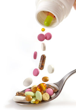 various pills falling into spoon