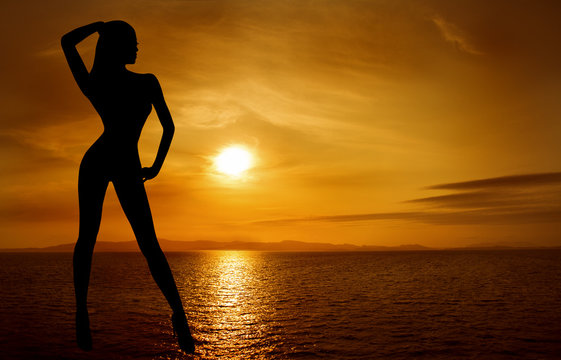 Woman sexy silhouette over sky sunset on sea