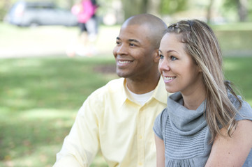 Obraz premium Happy young interracial couple posing together on a sunny day.