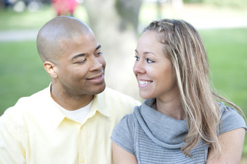 Fototapeta premium Happy young interracial couple posing together on a sunny day.