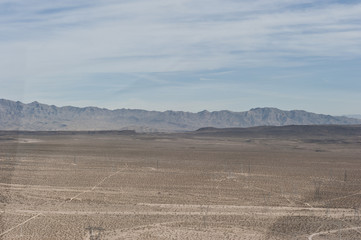 A dry desert view on a sunny day from a helicopter.