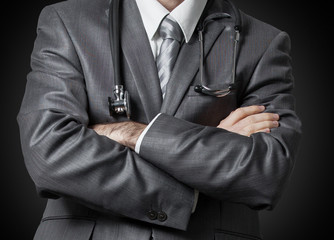 Serious doctor with stethoscope and arms crossed