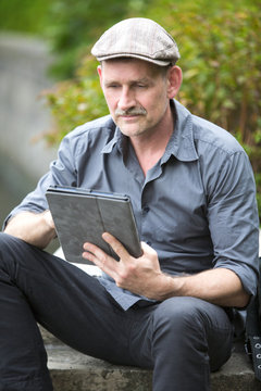 Man In Park With Tablet