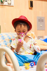 little boy lying in bed with inhalator mask