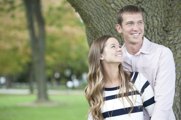 Fototapeta premium Young caucasian happy couple hugging in the park on a sunny day.
