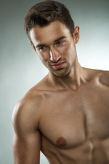 Handsome muscular man posing half naked, close-up photo