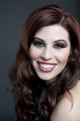 A young happy female model headshot in a studio.