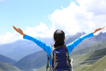 cheering hiking woman enjoy the beautiful view at mountain peak 