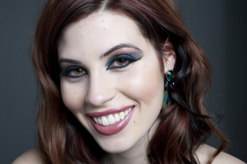 A young happy female model headshot in a studio.