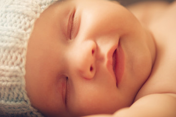 Portrait of cute newborn baby in a funny knitted hat