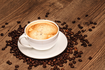 Coffee cup and saucer on a wooden table. with grains
