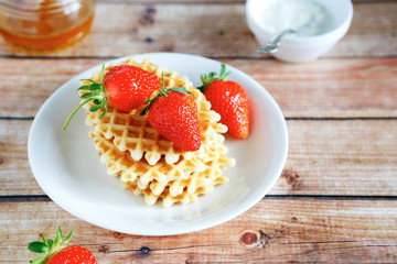 golden waffles with strawberries and honey