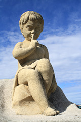 Fototapeta na wymiar Kinderstatue unter blauem Himmel in Frankreich