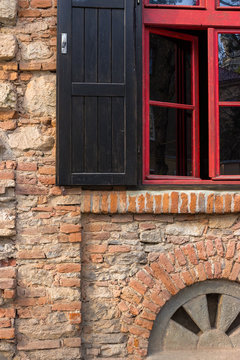 red frame window on a brick wall