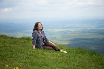 Middle aged woman sitting on the slope of volcano