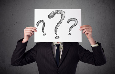 Businessman holding a paper with question marks in front of his