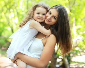 Fototapeta premium Portrait lovely mom and daughter in warm sunny summer day
