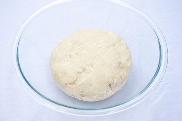 Handmade cookie dough in a glass bowl on a sunny day.