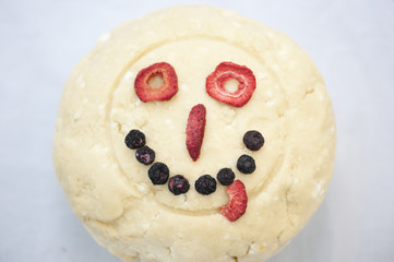 A round shaped cookie dough decorated with freeze dried fruits.