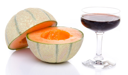 Glass of porto wine with a melon cut in half