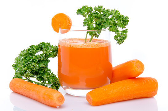 Composition with a glass of carrot juice, fresh carrots and pars